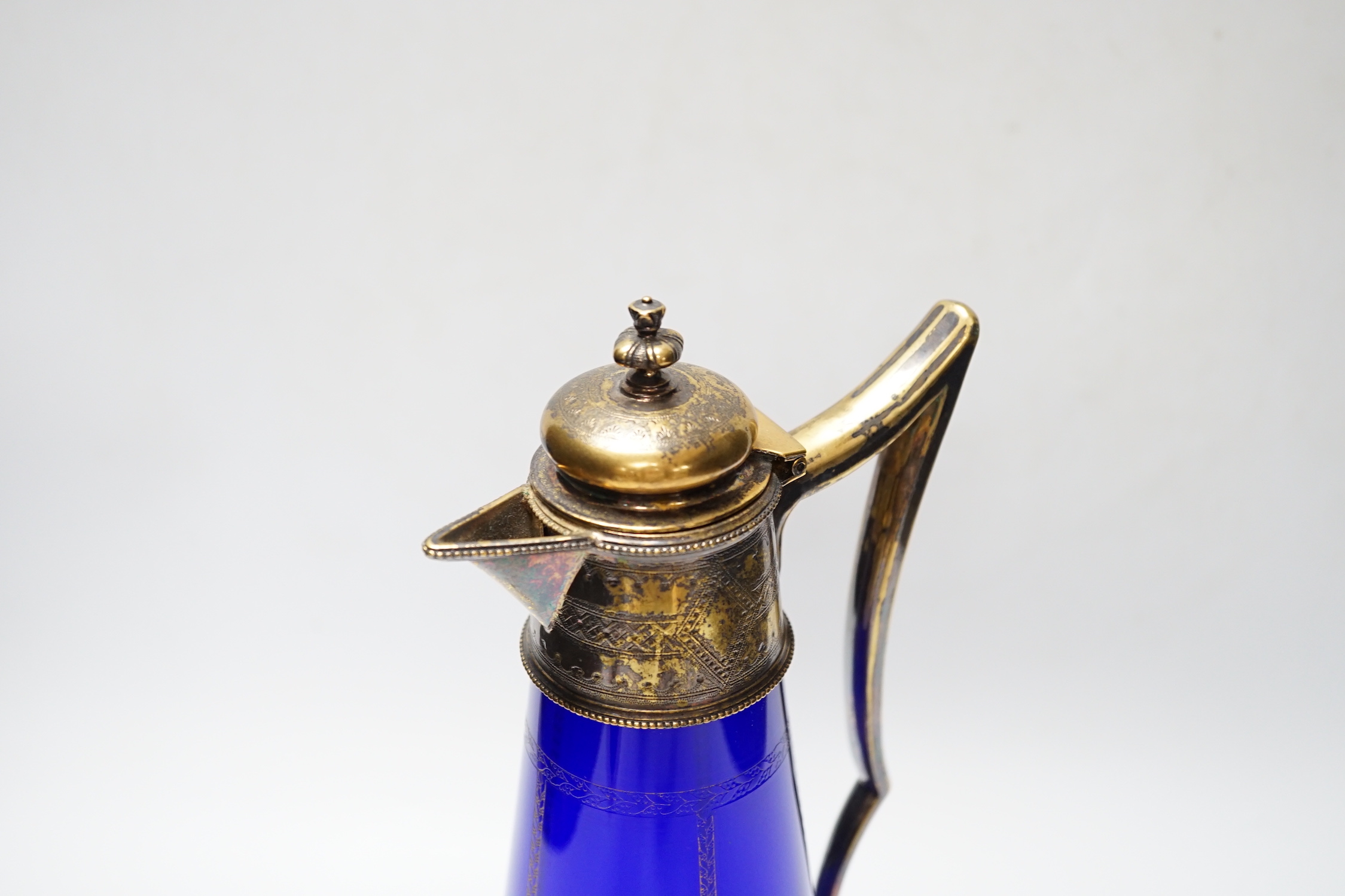 A 19th century Bristol blue cornucopia trumpet with metal hand mount with gilt decoration and a gilt decorated and mounted Bristol blue claret jug, jug 31.5cm high